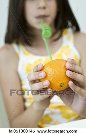 Girl drinking juice from orange half through straw View Large Photo Image Stock Photography - Girl drinking juice from orange half through straw. Fotosearch