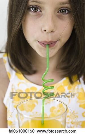 Girl drinking juice through curly straw View Large Photo Image Stock Image - Girl drinking juice through curly straw. Fotosearch