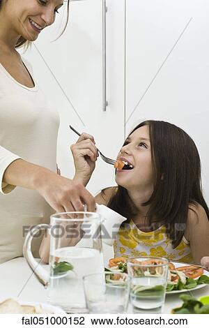 Girl eating salad, mother pouring salad dressing View Large Photo Image Stock Image - Girl eating salad, mother pouring salad dressing. Fotosearch