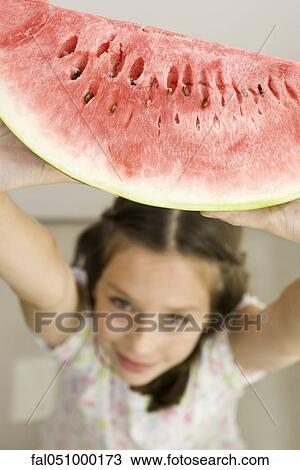 Girl holding up slice of watermelon View Large Photo Image Stock Image - Girl holding up slice of watermelon. Fotosearch