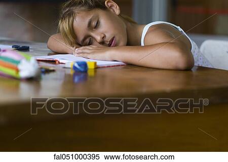 Girl resting head on arms asleep at desk View Large Photo Image Stock Photography - Girl resting head on arms asleep at desk. Fotosearch