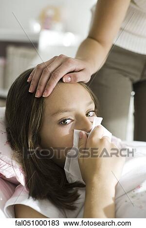 Girl with head cold, mother caressing forehead View Large Photo Image Stock Image - Girl with head cold, mother caressing forehead. Fotosearch