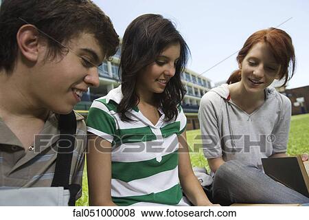 High school friends sitting together outdoors on grass View Large Photo Image Stock Photo - High school friends sitting together outdoors on grass. Fotosearch