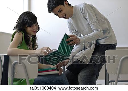 High school student showing book to classmate View Large Photo Image Picture - High school student showing book to classmate. Fotosearch
