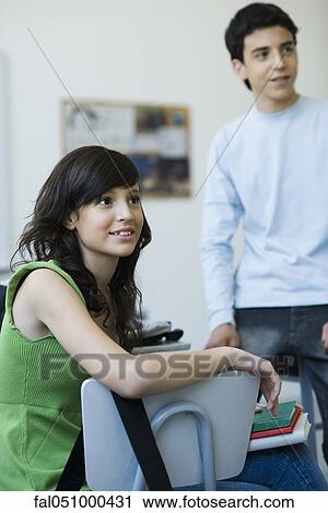 Stock Image - High school students hanging out in classroom. Fotosearch