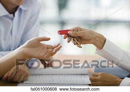 Stock Photo - Hotel receptionist handing room key to guest. Fotosearch