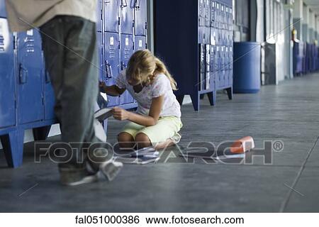 Junior high student picking up dropped school supplies, boy standing by watching View Large Photo Image Stock Photograph - Junior high student picking up dropped school supplies, boy standing by watching. Fotosearch