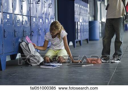 Junior high student picking up dropped school supplies, boy standing by watching View Large Photo Image Stock Photography - Junior high student picking up dropped school supplies, boy standing by watching. Fotosearch
