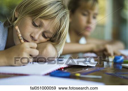 Junior high student resting head on arm while writing assignment View Large Photo Image Stock Photo - Junior high student resting head on arm while writing assignment. Fotosearch