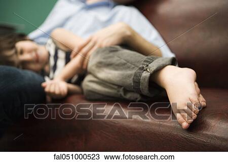 Little boy resting with head in father's lap View Large Photo Image Stock Image - Little boy resting with head in father's lap. Fotosearch