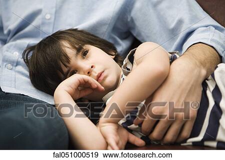 Little boy resting with head in father's lap View Large Photo Image Stock Photo - Little boy resting with head in father's lap. Fotosearch