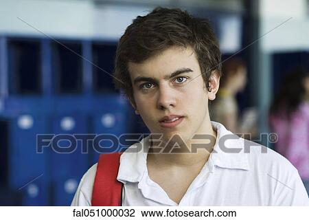 Male high school student standing in hall lined with lockers, portrait View Large Photo Image Stock Image - Male high school student standing in hall lined with lockers, portrait. Fotosearch