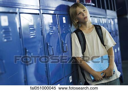 Male junior high student leaning against lockers looking away View Large Photo Image Stock Photography - Male junior high student leaning against lockers looking away. Fotosearch