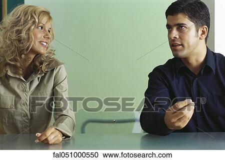 Man and woman sitting at table with empty chair between them, having conversation View Large Photo Image Stock Image - Man and woman sitting at table with empty chair between them, having conversation. Fotosearch
