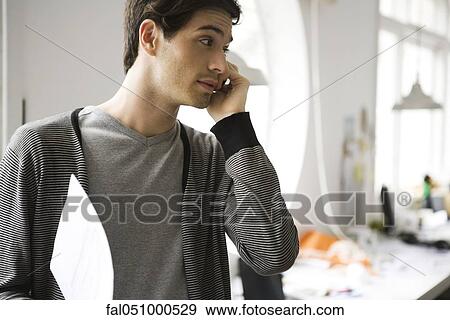 Man holding document on phone call View Large Photo Image Stock Photo - Man holding document on phone call. Fotosearch