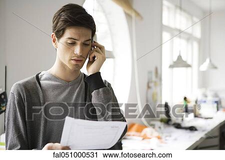 Man holding document, talking on cell phone View Large Photo Image Stock Image - Man holding document, talking on cell phone. Fotosearch
