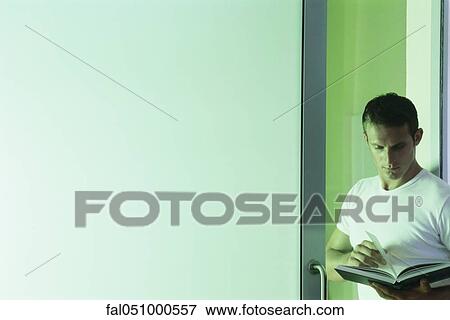 Man leaning in doorway, reading book View Large Photo Image Stock Photo - Man leaning in doorway, reading book. Fotosearch