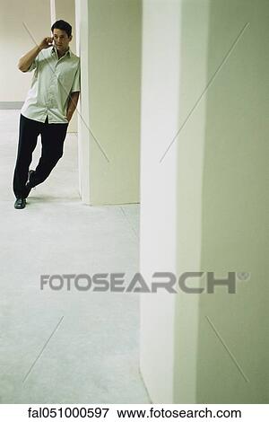 Man leaning in doorway, talking on cell phone View Large Photo Image Stock Photo - Man leaning in doorway, talking on cell phone. Fotosearch