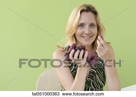 Mature woman eating grapes View Large Photo Image Stock Image - Mature woman eating grapes. Fotosearch