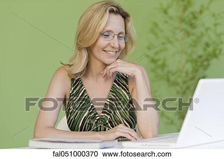 Stock Image - Mature woman using laptop computer. Fotosearch
