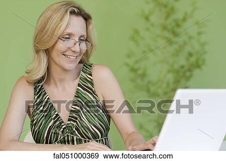 Mature woman using laptop computer View Large Photo Image Stock Photo - Mature woman using laptop computer. Fotosearch