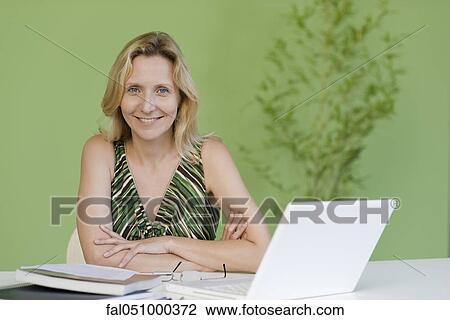 Mature woman with book and laptop computer, portrait View Large Photo Image Stock Image - Mature woman with book and laptop computer, portrait. Fotosearch