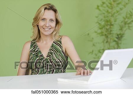 Stock Photography - Mature woman with laptop computer, portrait. Fotosearch