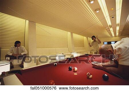 Stock Photograph - Men playing pool in pool hall. Fotosearch