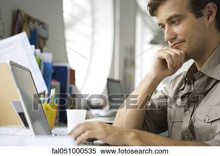 Mid-adult man using laptop computer View Large Photo Image Stock Photography - Mid-adult man using laptop computer. Fotosearch