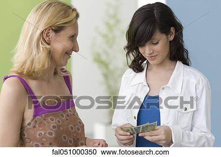 Mother giving teenage daughter pocket money View Large Photo Image Stock Image - Mother giving teenage daughter pocket money. Fotosearch