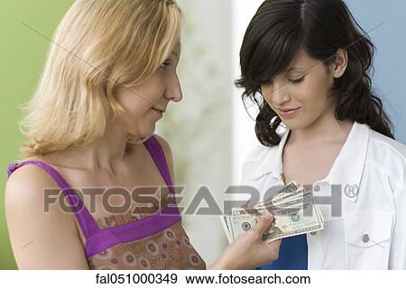 Mother giving teenage daughter pocket money View Large Photo Image Stock Photo - Mother giving teenage daughter pocket money. Fotosearch