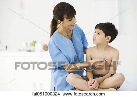Nurse examining boy with stethoscope View Large Photo Image Picture - Nurse examining boy with stethoscope. Fotosearch