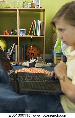 Preteen boy using laptop computer View Large Photo Image Stock Photography - Preteen boy using laptop computer. Fotosearch