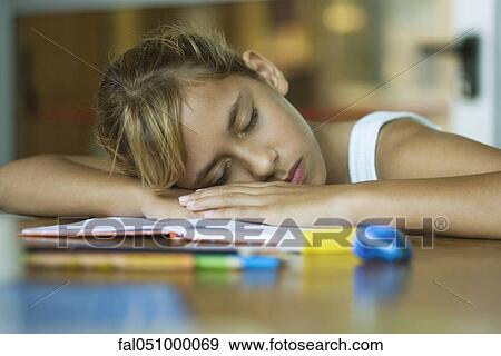Preteen girl napping, resting head on arms laid across open book View Large Photo Image Stock Photo - Preteen girl napping, resting head on arms laid across open book. Fotosearch