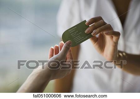 Stock Photograph - Professional handing business card to client. Fotosearch