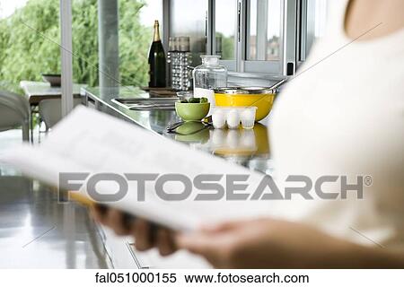 Reading recipe in cookbook, ingredients on kitchen counter in background View Large Photo Image Stock Photography - Reading recipe in cookbook, ingredients on kitchen counter in background. Fotosearch