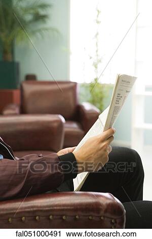Stock Image - Relaxing with newspaper. Fotosearch