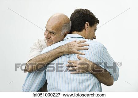 Stock Photo - Senior man embracing adult son. Fotosearch