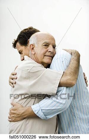 Senior man embracing adult son View Large Photo Image Stock Photograph - Senior man embracing adult son. Fotosearch
