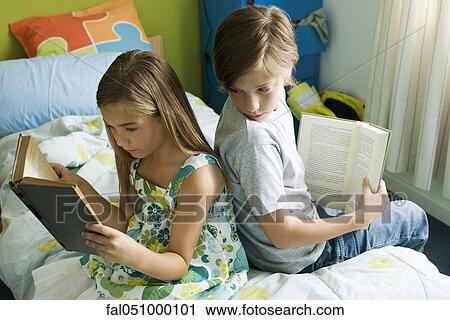 Siblings reading together, boy glancing over shoulder at sister's book View Large Photo Image Stock Image - Siblings reading together, boy glancing over shoulder at sister's book. Fotosearch