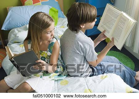 Siblings reading together, girl glancing over shoulder at brother's book View Large Photo Image Stock Image - Siblings reading together, girl glancing over shoulder at brother's book. Fotosearch