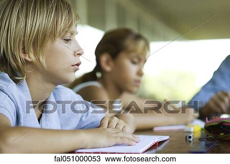 Student in class with book, looking away with boredom View Large Photo Image Stock Image - Student in class with book, looking away with boredom. Fotosearch