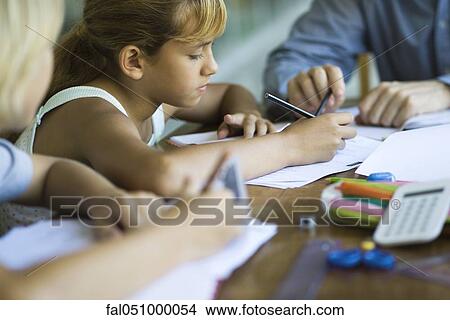 Picture - Student working on classwork, teacher helping. Fotosearch