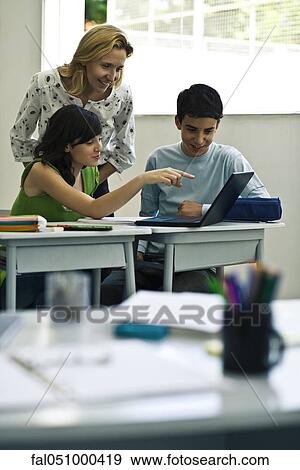 Teacher and students using laptop computer in class View Large Photo Image Stock Photo - Teacher and students using laptop computer in class. Fotosearch