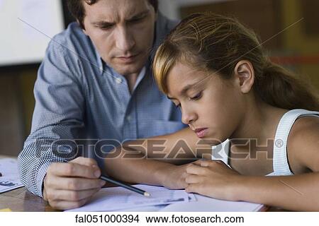 Picture - Teacher helping elementary school student in class. Fotosearch