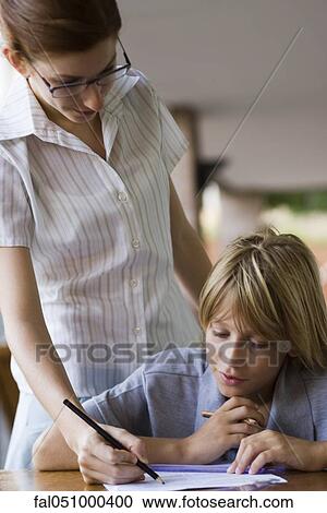 Teacher helping elementary school student in class View Large Photo Image Stock Image - Teacher helping elementary school student in class. Fotosearch