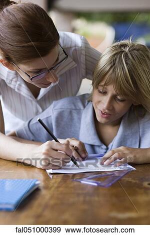 Teacher helping elementary school student in class View Large Photo Image Stock Photo - Teacher helping elementary school student in class. Fotosearch