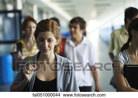 Teacher walking along hall listening to students chatting together View Large Photo Image Picture - Teacher walking along hall listening to students chatting together. Fotosearch