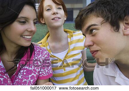 Teenage boy playfully looking at girl friend with playful expression View Large Photo Image Stock Photo - Teenage boy playfully looking at girl friend with playful expression. Fotosearch