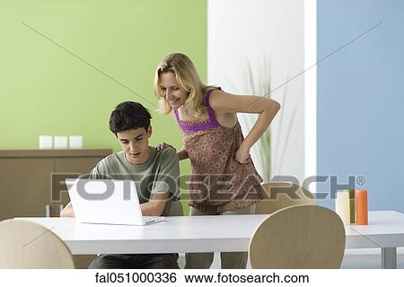 Teenage boy showing mother laptop computer View Large Photo Image Stock Photograph - Teenage boy showing mother laptop computer. Fotosearch